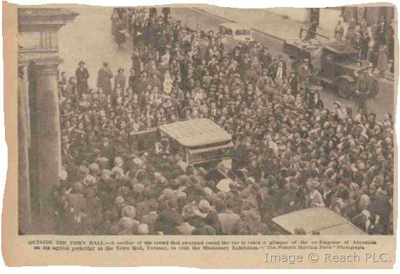 Photograph of Haile Selassie arriving at Torquay Town Hall.  His car is surrounded by people excited to see him.  Published in the Western Morning News, 12 October 1937.  Reproduced by kind permission of Mirrorpix.